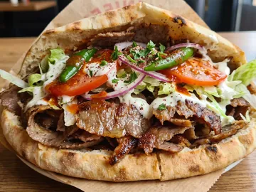 Kebab en pain avec salade, tomate, oignon rouge et sauce à l'ail